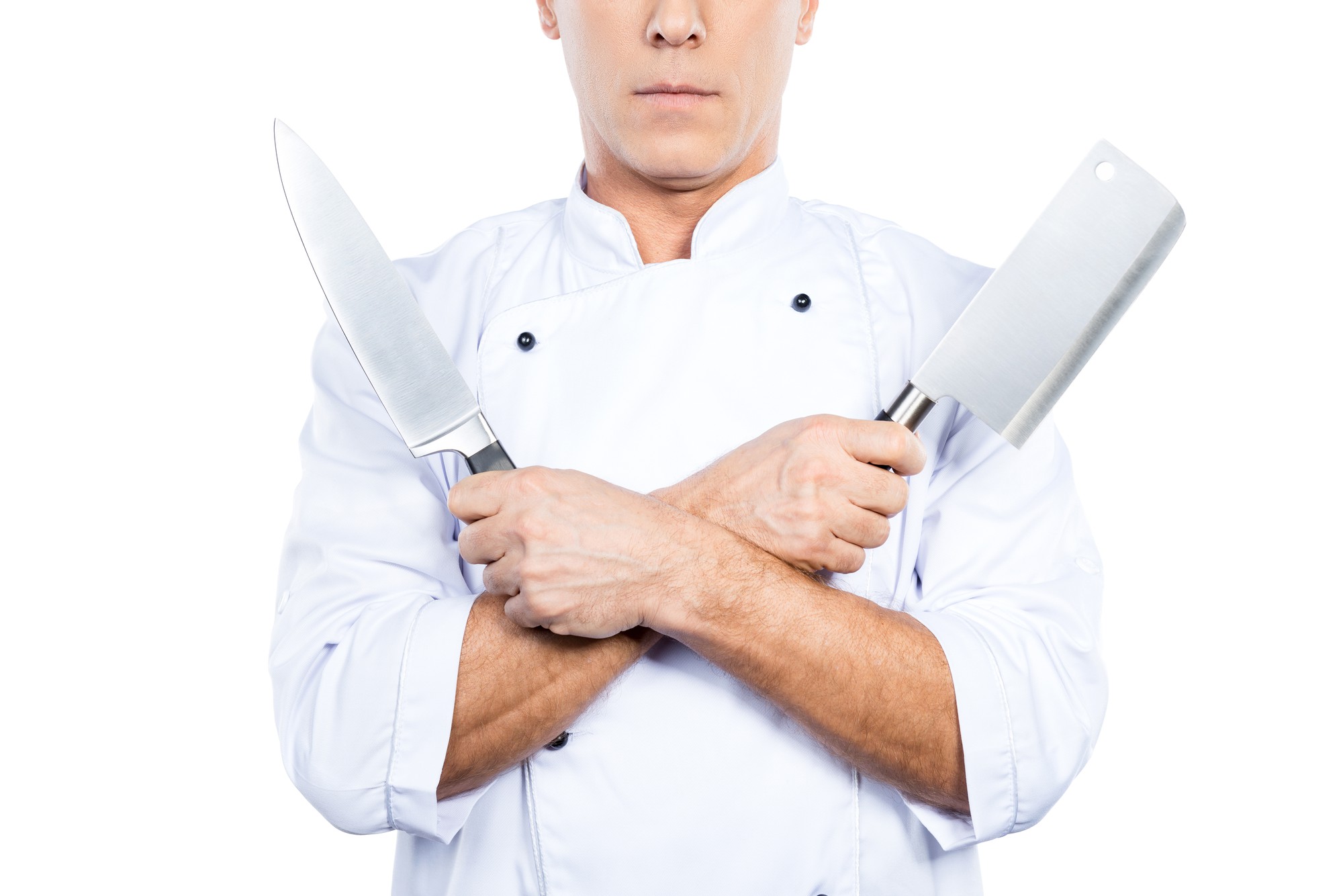 Chef che dimostra una tecnica di taglio in una cucina luminosa
